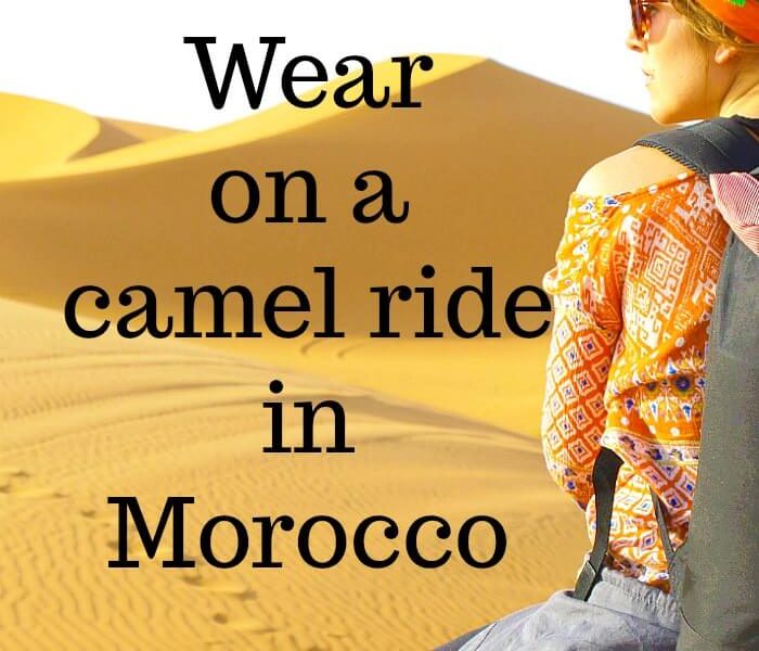 Back view of a girl on a camel in the Sahara. Camel prints are embedded in the sand and the words What to Wear on a camel ride in Morocco
