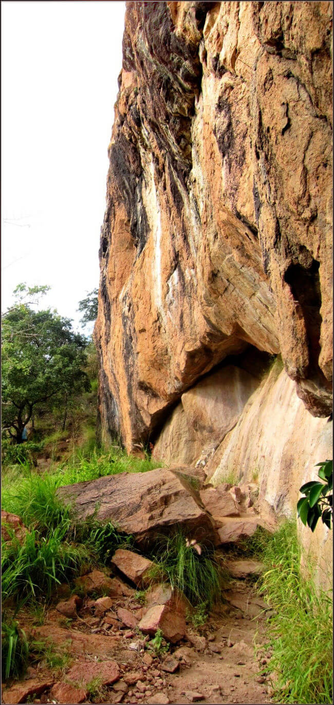 a photo of the castle hill goat track passing close to the sheer rock face of castle hill townsville