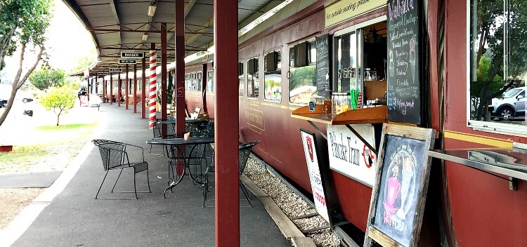 Shop signs table and chairs beside the red Margate Train in Tasmania