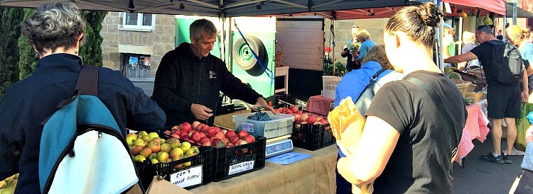 Red and Green Surges Bay Orchard Apples stacked in black boxes at Farm Gate Market Hobart
