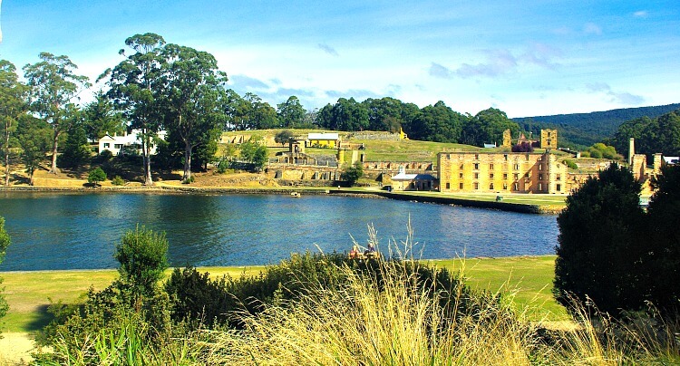 Looking across blue water to the remains of convict built buildings at Port Arthur Tasmania